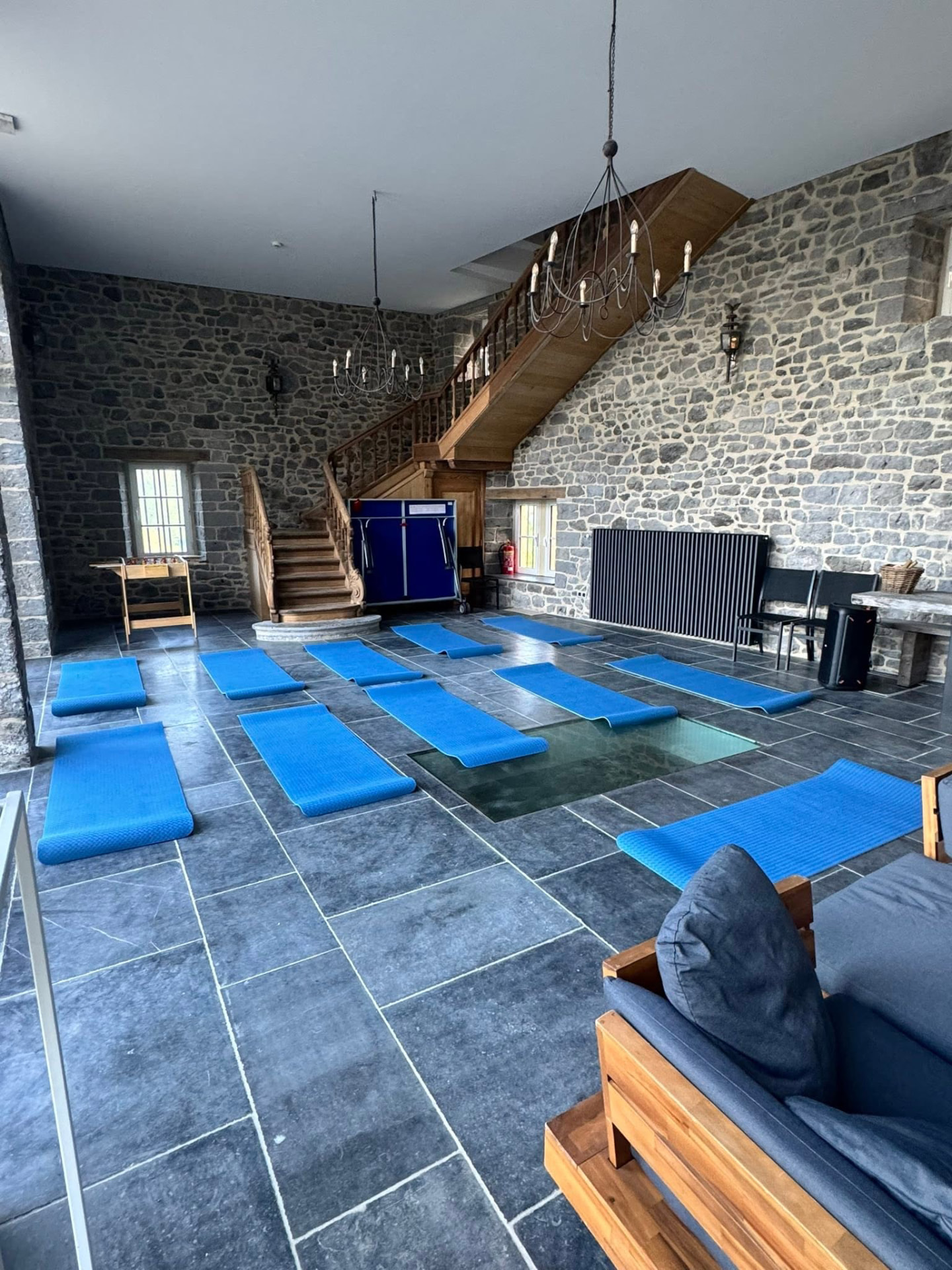 Yoga mats laid out in a stone retreat hall ready for practice