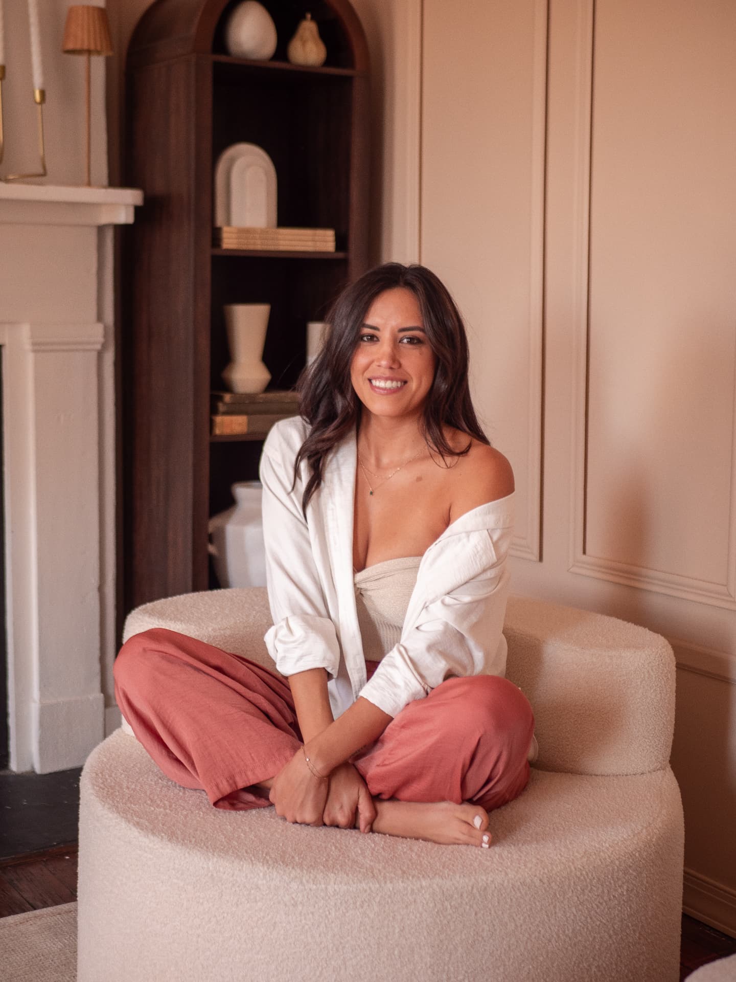 Kiabeth Hiltgen smiling while seated in a rust velvet armchair